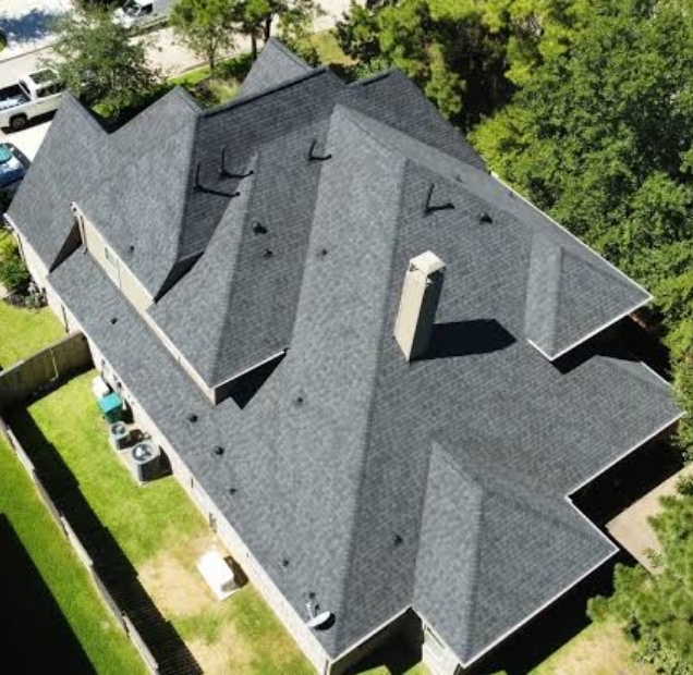 Aerial view of a new gray shingle roof on a house with several gables